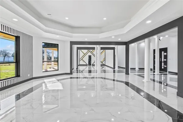 a large kitchen with kitchen island a large counter top a sink a counter space and stainless steel appliances