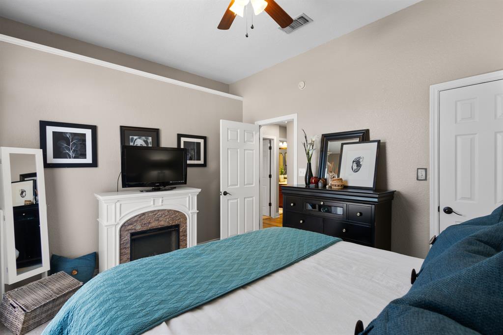 1701 Oakmeadow Drive Decatur, TX 76234 - Photo 24 of 39 a bedroom with a bed and a fireplace