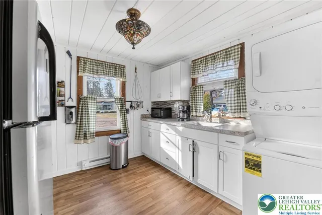 a kitchen with stainless steel appliances a white table chairs and a window