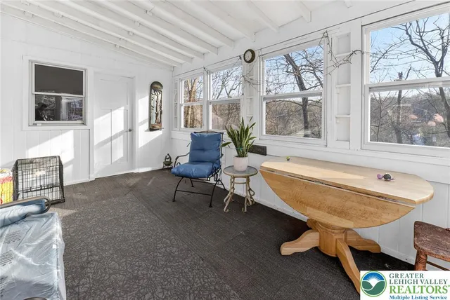 a living room with furniture a large window and a chandelier
