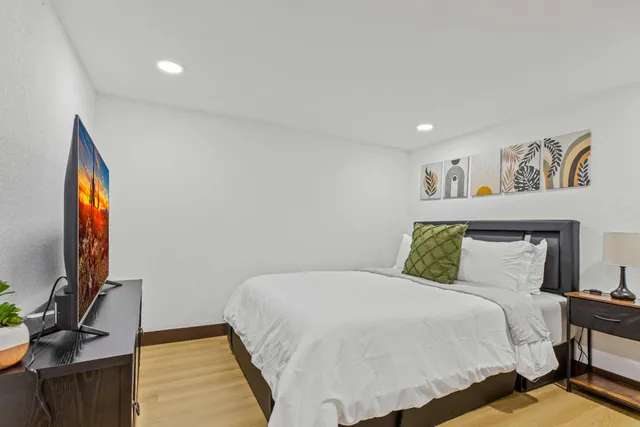 a bedroom with a bed and painting on the wall