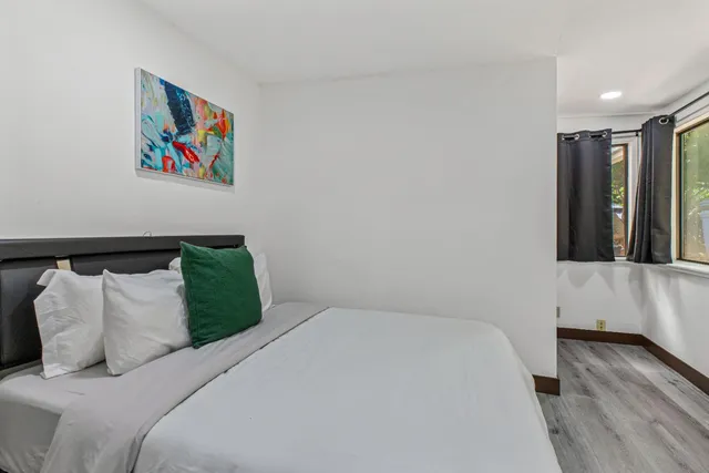 a bedroom with a bed and a painting on the wall