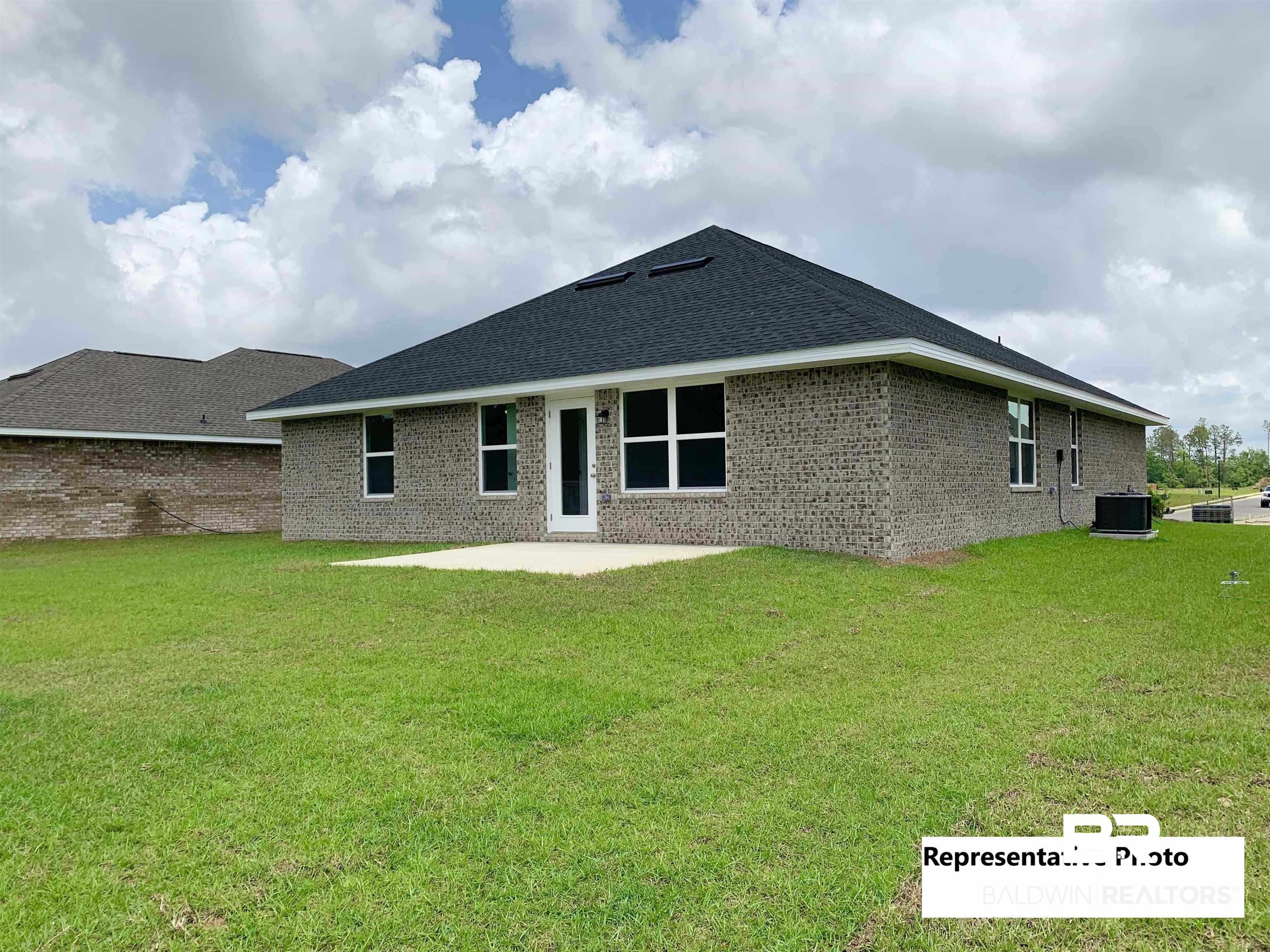 645 Revere Street Foley, AL 36535 - Photo 13 of 14 Back of house featuring central air condition unit, a patio area, and a yard