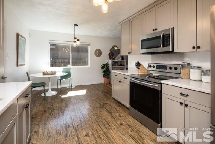 641 Beldon Way Reno, NV 89503 - Photo 8 of 21 a kitchen with stainless steel appliances a stove top oven a sink dishwasher and white cabinets with wooden floor