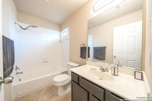 a bathroom with a sink a toilet and a large mirror