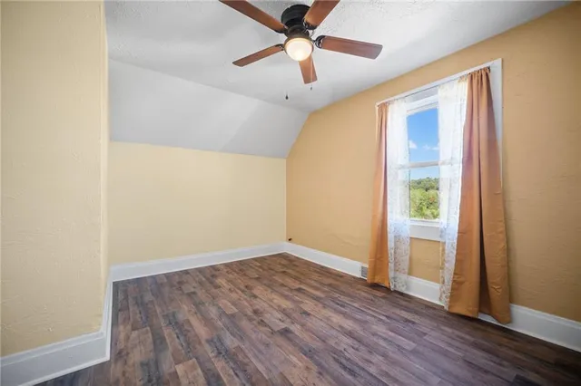 a view of a room with wooden floor and windows
