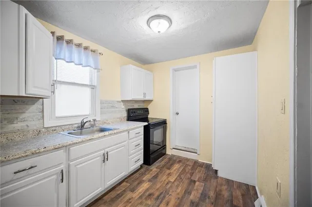 a kitchen with a sink cabinets stainless steel appliances and a window
