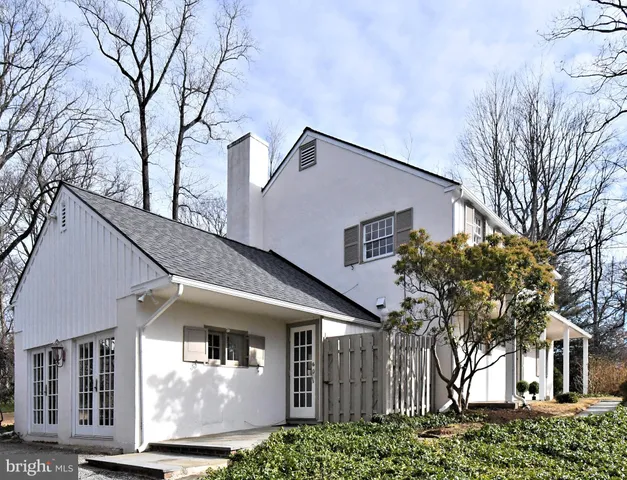 a front view of a house with a tree