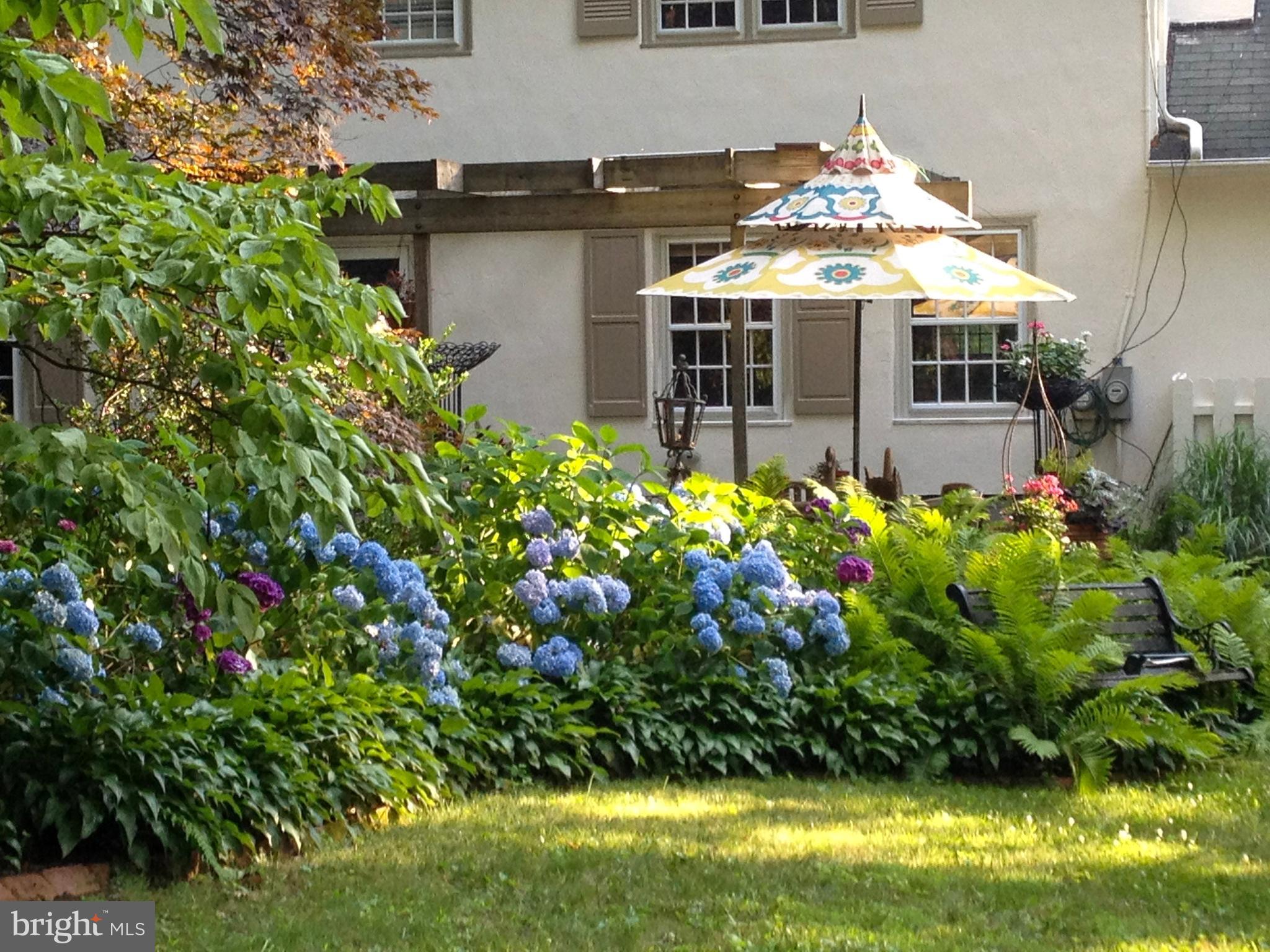 457 School House Lane Devon, PA 19333 - Photo 88 of 93 a view of a house with lots of flower plants and large tree