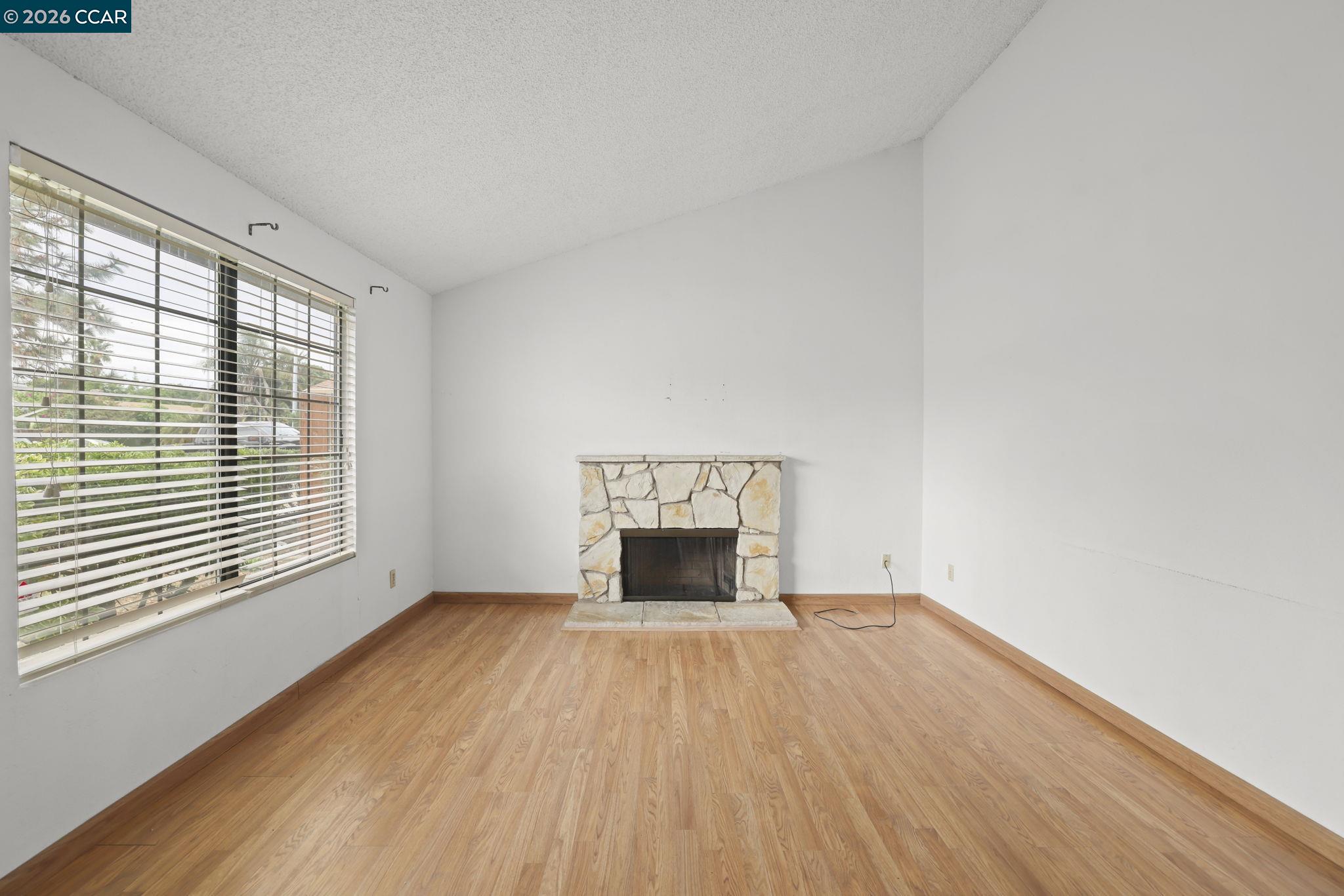 3438 Gregory Drive Bay Point, CA 94565 - Photo 4 of 24 an empty room with wooden floor fireplace and windows