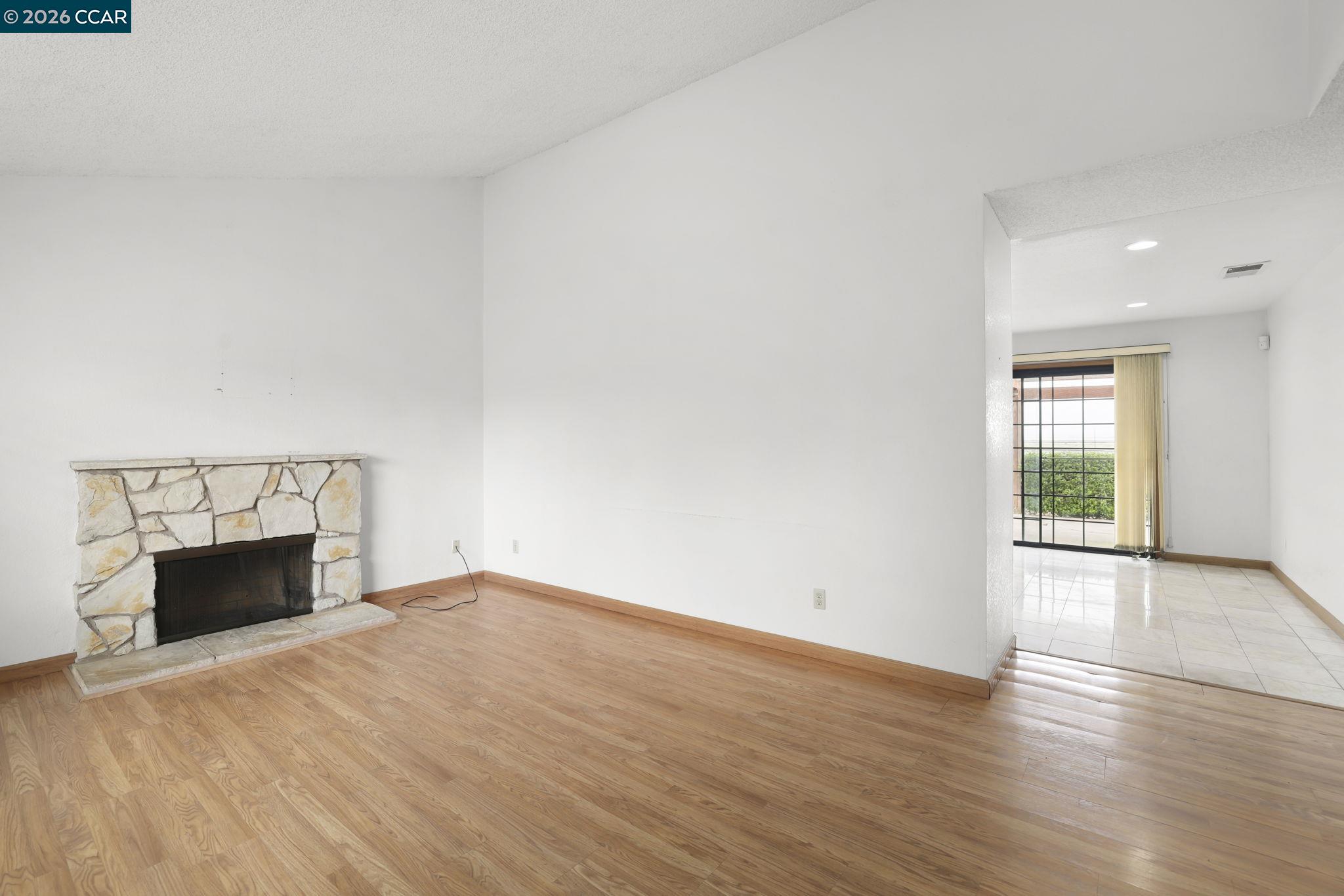 3438 Gregory Drive Bay Point, CA 94565 - Photo 6 of 24 an empty room with wooden floor fireplace and windows