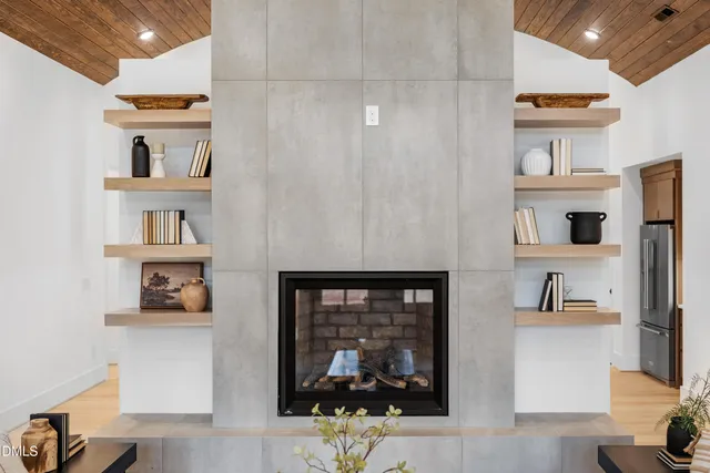 a kitchen with stainless steel appliances kitchen island granite countertop a refrigerator a stove a sink a dining table and chairs with wooden floor