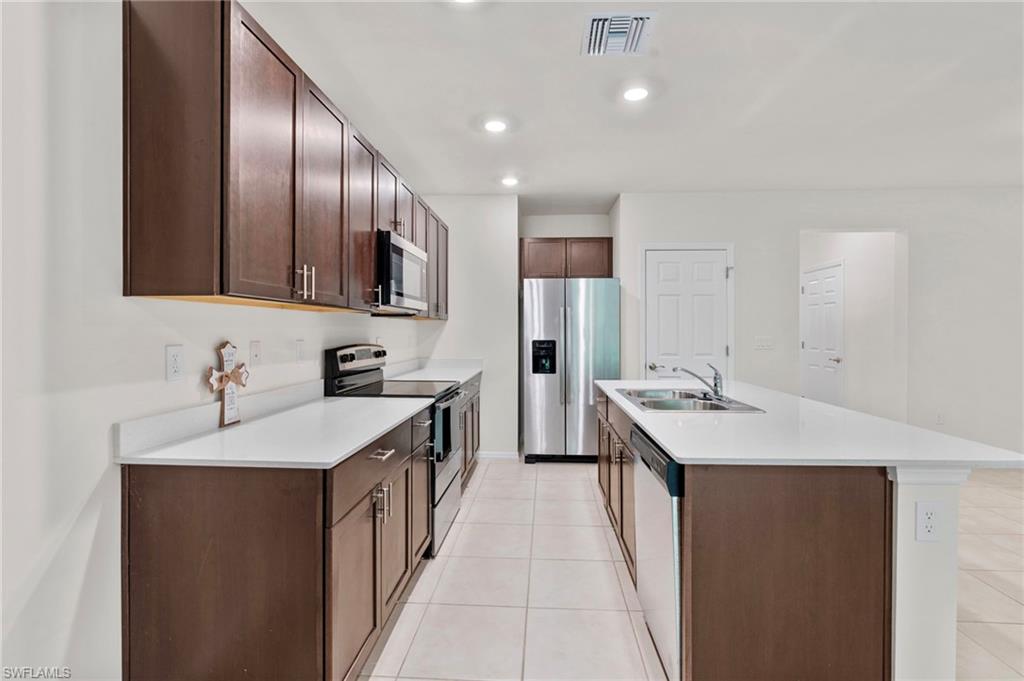 15535 Wildflower Circle Naples, FL 34119 - Photo 3 of 33 a kitchen with a sink stove and cabinets