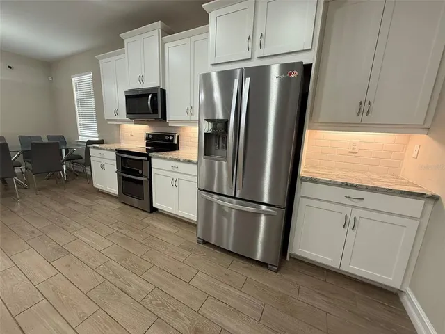 a kitchen with stainless steel appliances a refrigerator sink and microwave