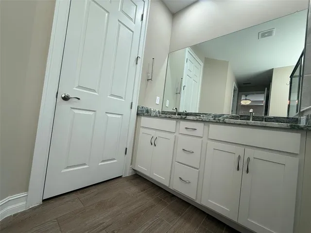 a bathroom with a granite countertop sink and a mirror