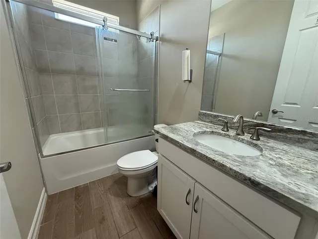 a bathroom with a granite countertop sink toilet and shower
