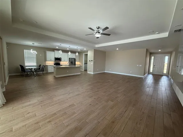 a view of a living room and kitchen with furniture wooden floor