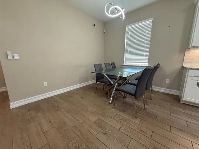 a workspace room with wooden floor and a window