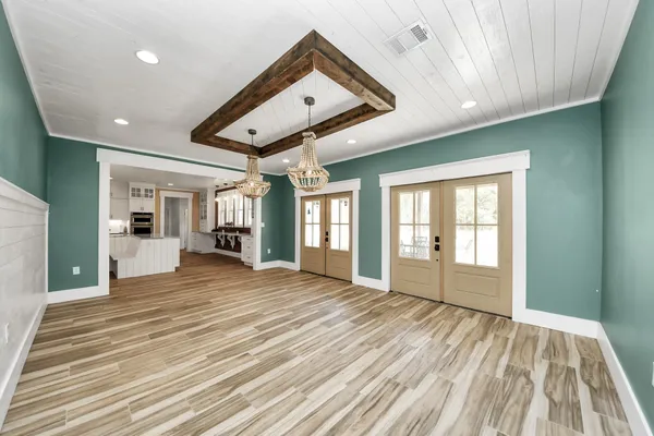 a view of a hallway with wooden floor and staircase