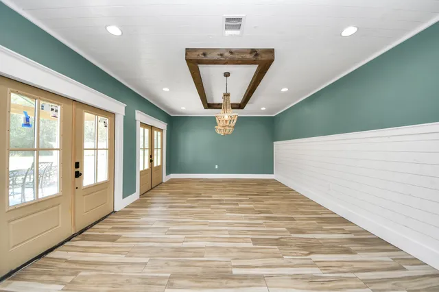 a view of a hallway with a window and wooden floor