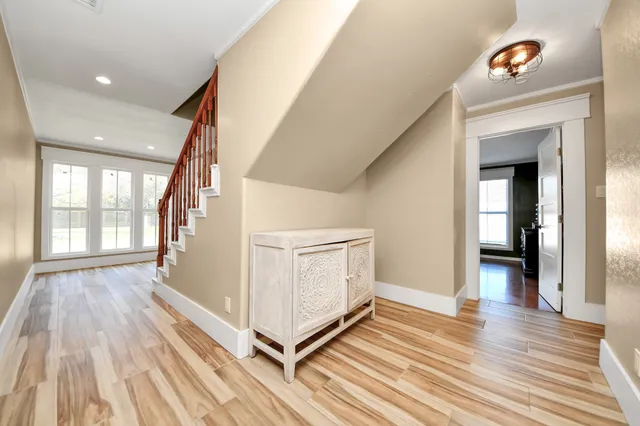 a view of a hallway with wooden floor and staircase