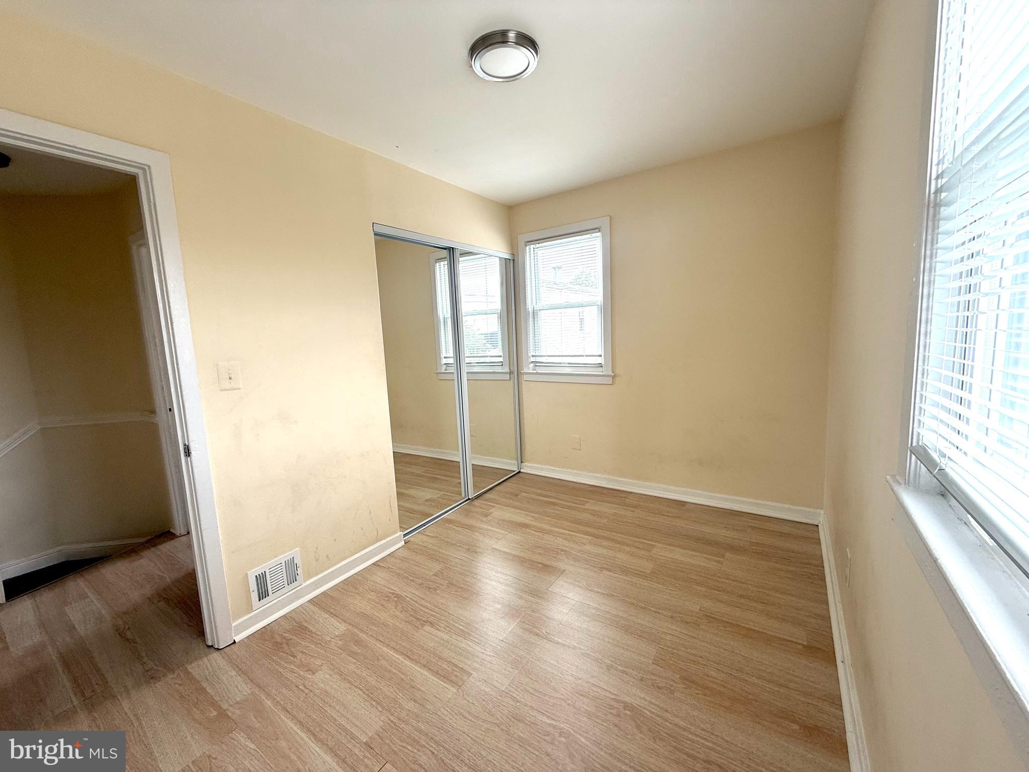2852 Iverson Street, Unit 110 Temple Hills, MD 20748 - Photo 14 of 23 an empty room with wooden floor and windows
