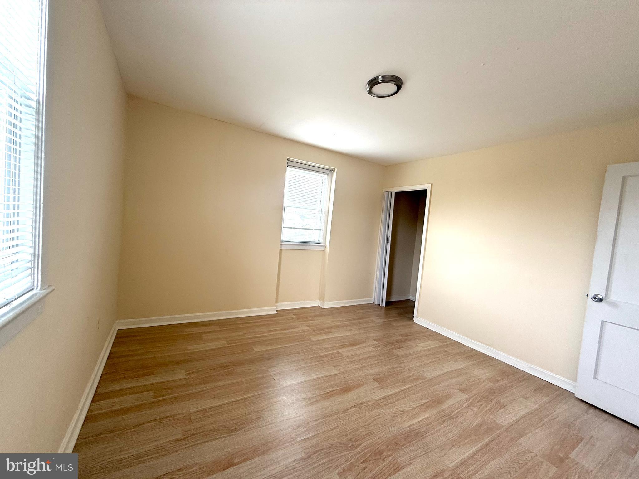 2852 Iverson Street, Unit 110 Temple Hills, MD 20748 - Photo 16 of 23 an empty room with wooden floor and windows