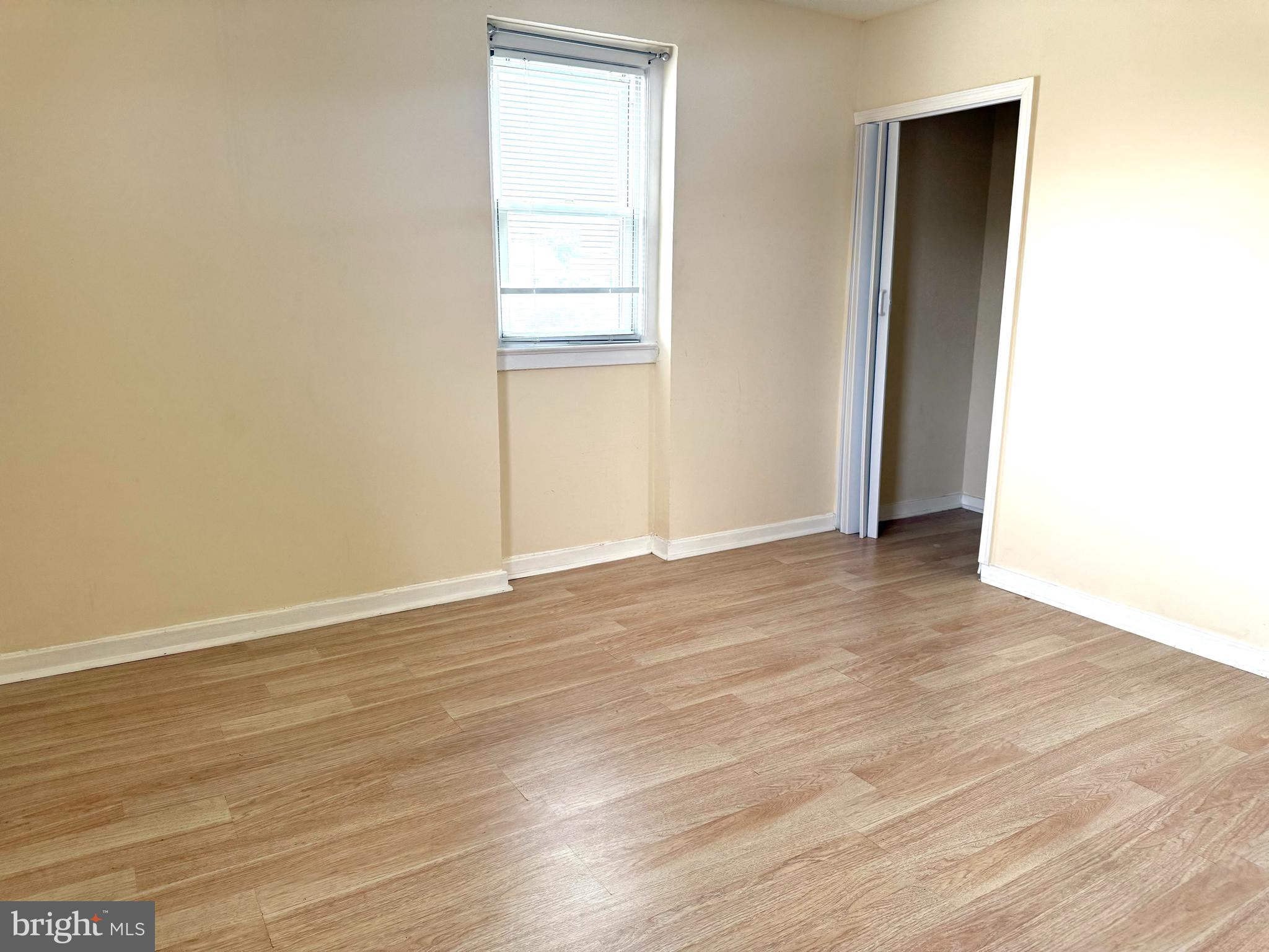 2852 Iverson Street, Unit 110 Temple Hills, MD 20748 - Photo 17 of 23 an empty room with wooden floor and windows