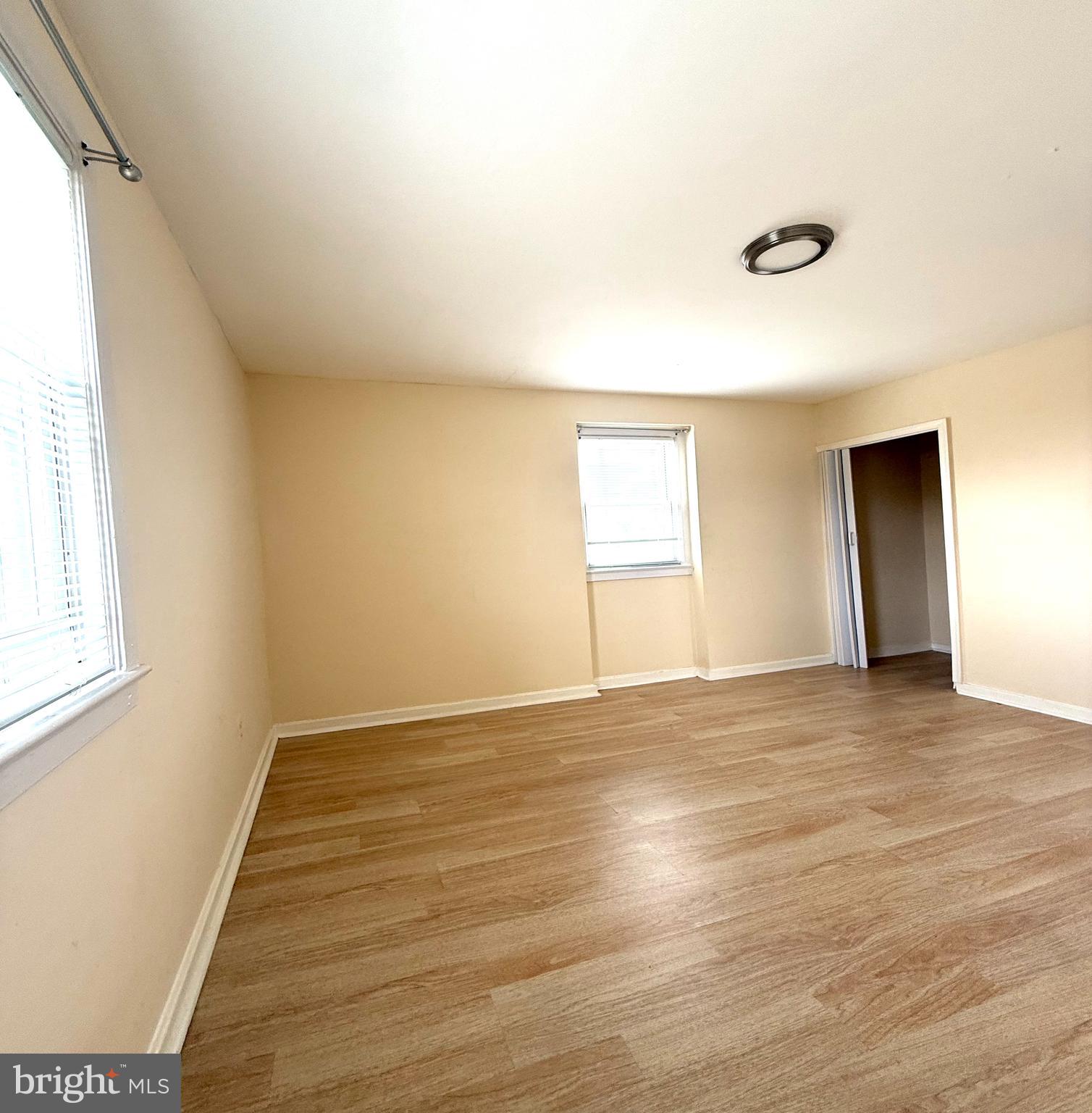 2852 Iverson Street, Unit 110 Temple Hills, MD 20748 - Photo 18 of 23 an empty room with wooden floor and windows