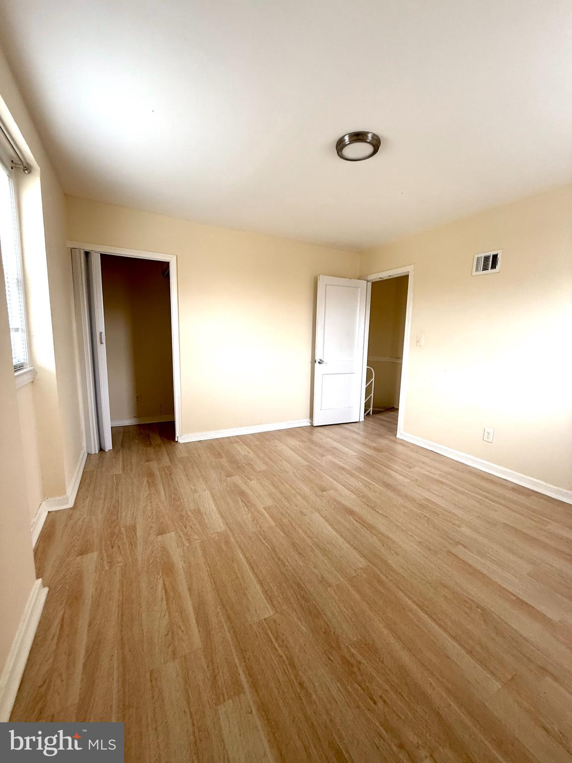 2852 Iverson Street, Unit 110 Temple Hills, MD 20748 - Photo 19 of 23 an empty room with wooden floor and windows