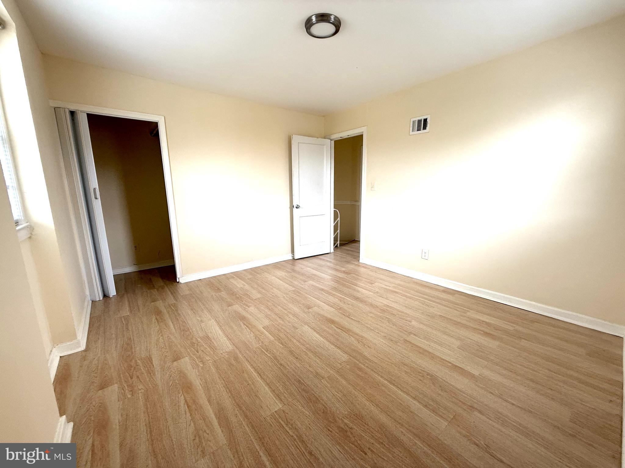 2852 Iverson Street, Unit 110 Temple Hills, MD 20748 - Photo 20 of 23 an empty room with wooden floor and windows