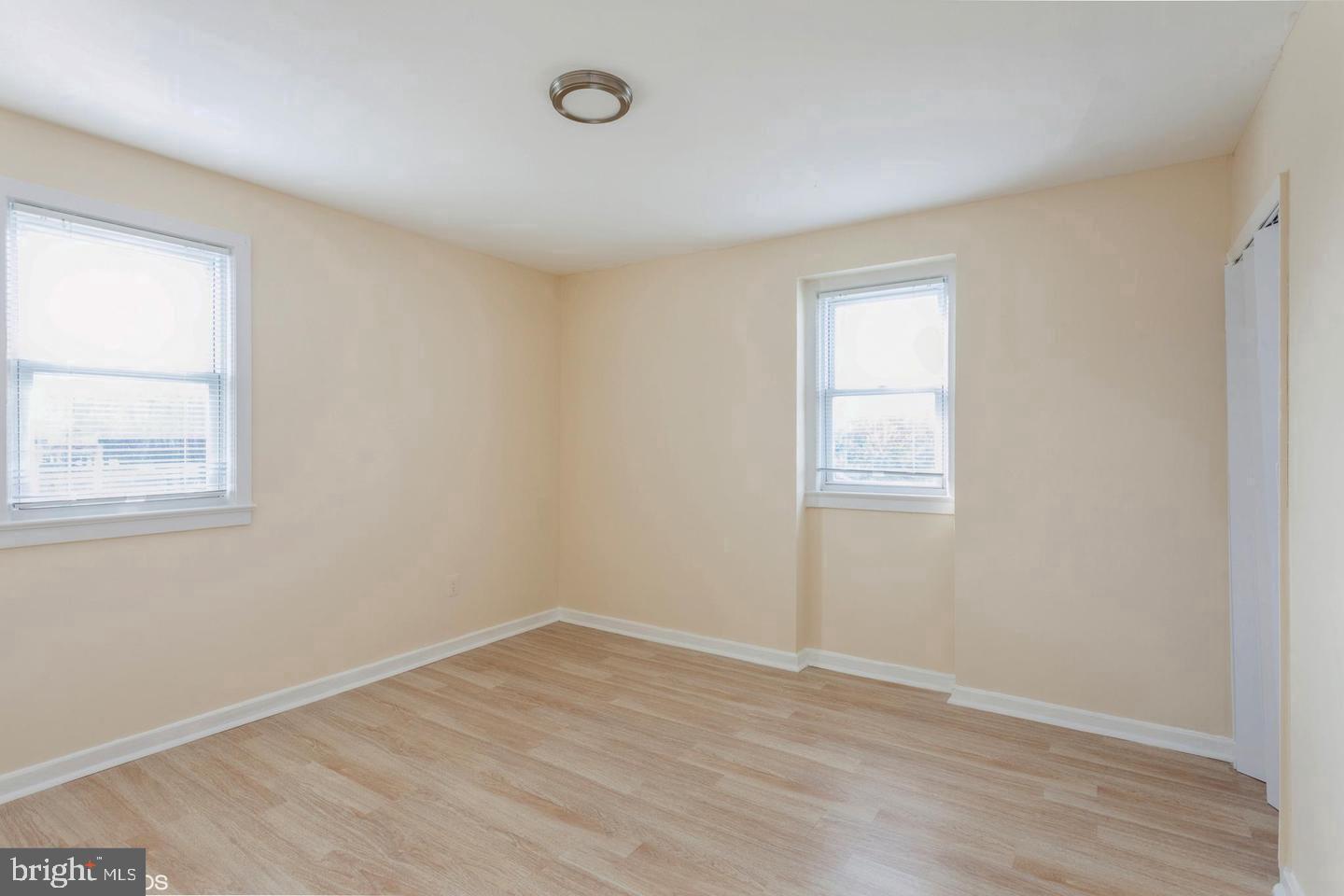 2852 Iverson Street, Unit 110 Temple Hills, MD 20748 - Photo 21 of 23 an empty room with wooden floor and windows