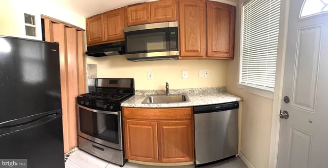 a kitchen with stainless steel appliances granite countertop a stove a sink and a refrigerator