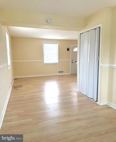 a view of a room with wooden floor and a window