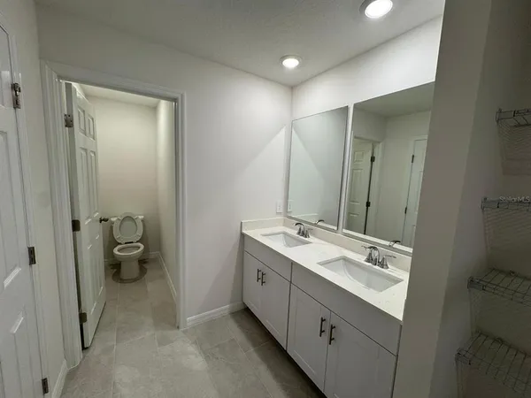 a bathroom with a double vanity sink toilet and a mirror