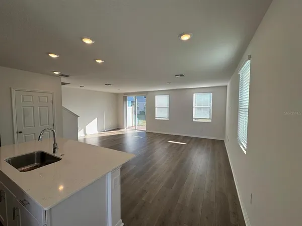 a view of a kitchen counter space windows and wooden floor