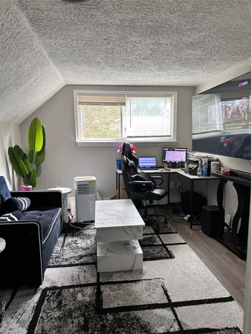 a room with furniture a flat screen tv and a window