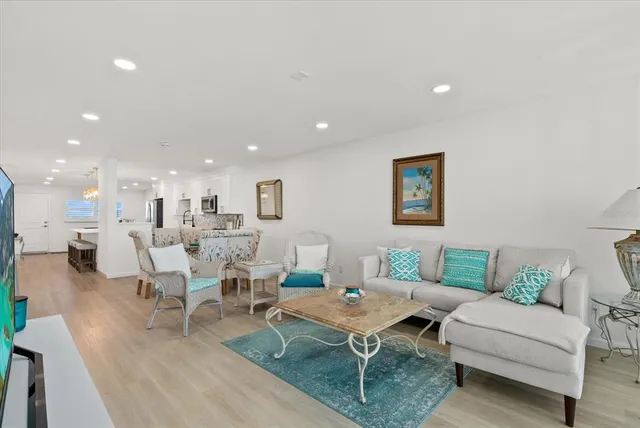 a living room with lots of furniture and view of kitchen