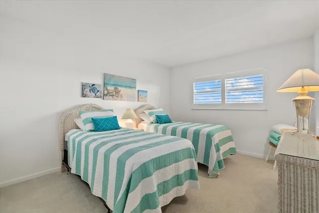 a bedroom with two beds and a wooden floor