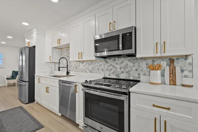 a kitchen with stainless steel appliances a stove microwave and sink