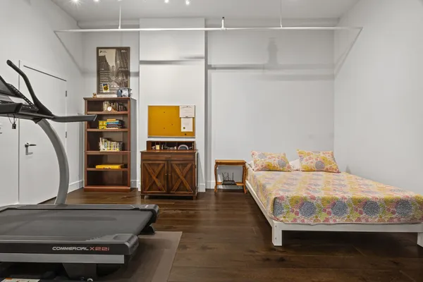 a bedroom with bed and wooden floor