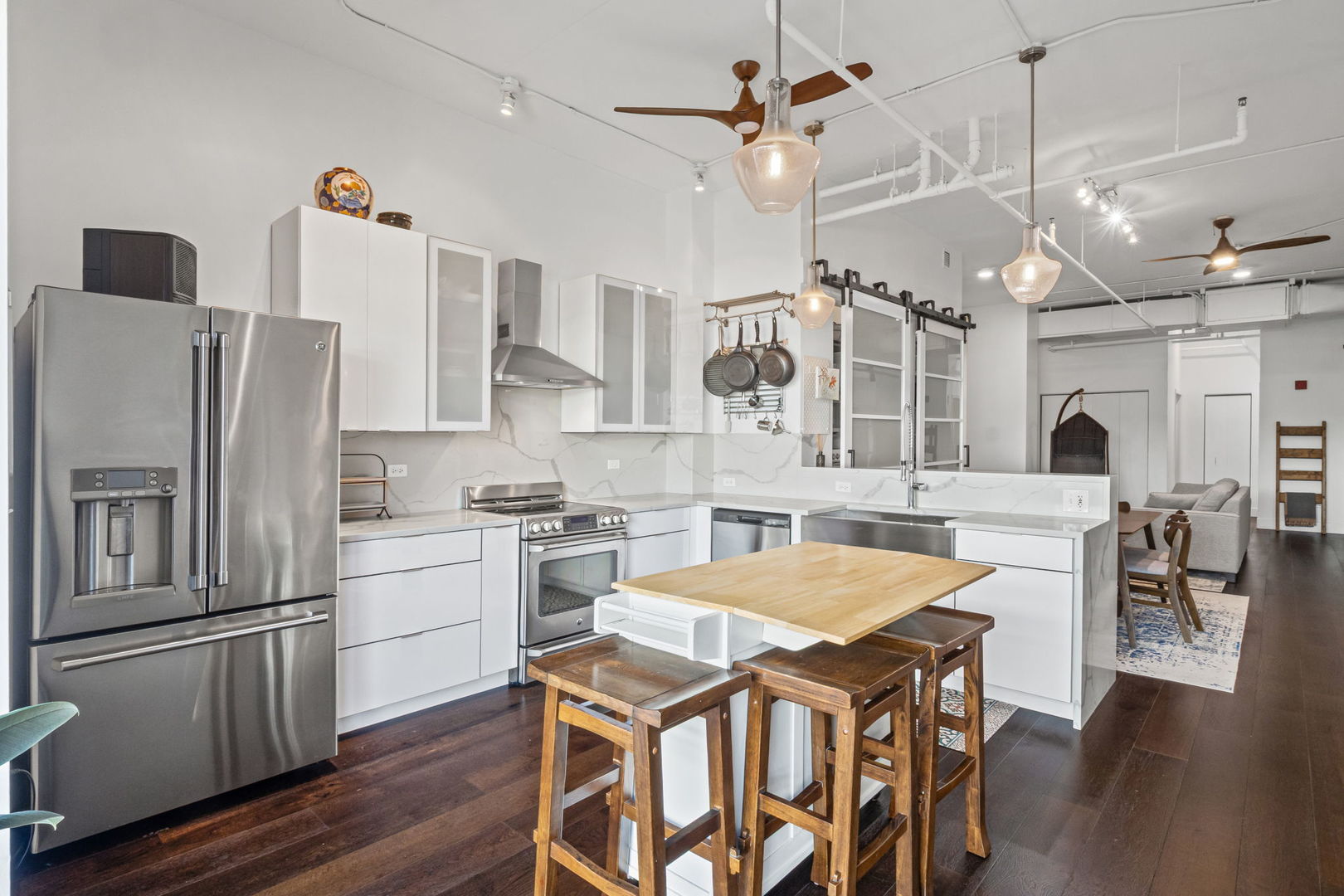1640 Maple Avenue, Unit 304 Evanston, IL 60201 - Photo 5 of 25 a kitchen with stainless steel appliances a stove a refrigerator a oven a kitchen island with wooden floor and cabinets