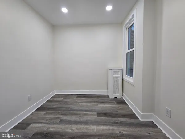 a view of a room with wooden floor table and chairs