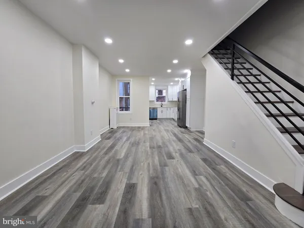 a view of a hallway with wooden floor and staircase