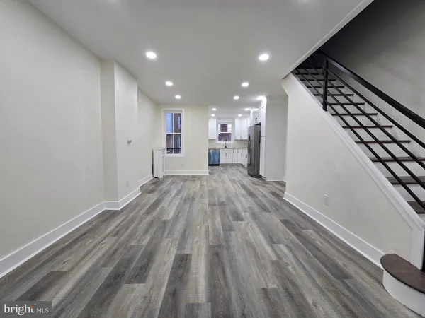 a view of a big room with wooden floor and staircase