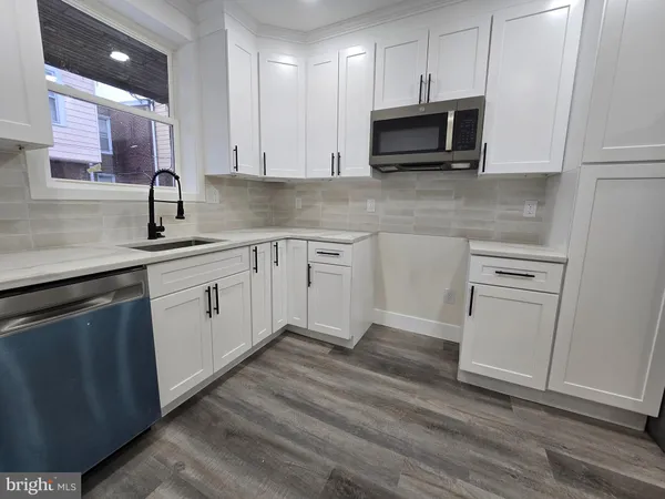 a kitchen with stainless steel appliances granite countertop a sink stove and microwave