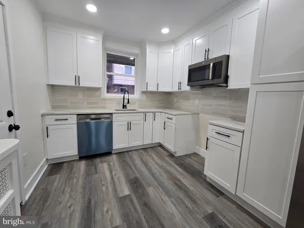 a kitchen with appliances a sink and cabinets