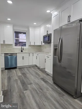 a kitchen with granite countertop a refrigerator and a sink