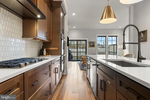 a kitchen with kitchen island granite countertop a sink a counter space appliances and cabinets