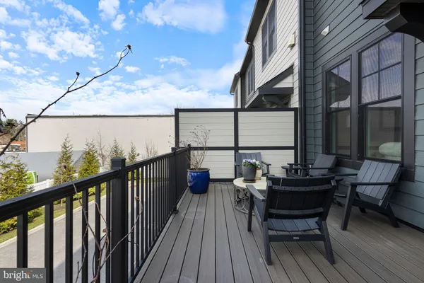 a balcony with wooden floor table and chairs